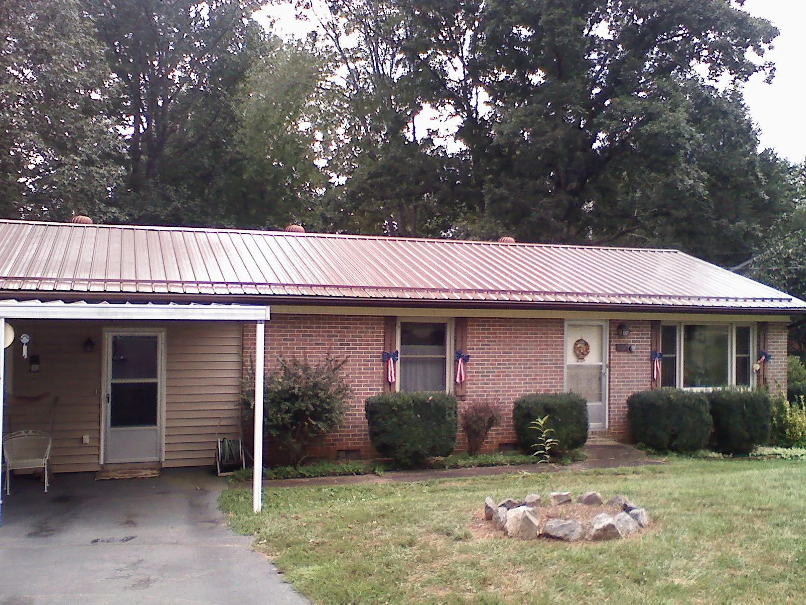 Bronze metal roof and carport on a brick ranch home — Roof Repair work by our crew in Divernon